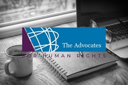 [ai] A coffee cup and a notebook on a wooden desk beside a laptop. The logo of 'The Advocates for Human Rights' is prominently displayed with a blue background and white graphic elements.